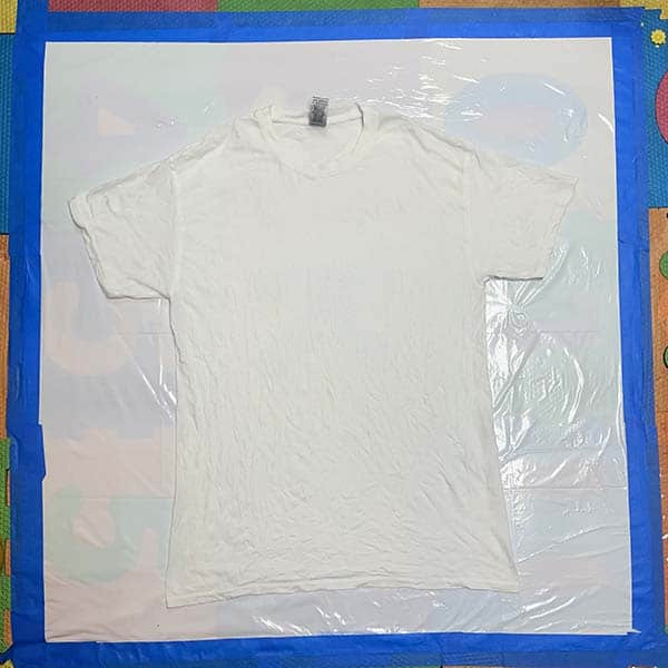 Laying damp shirt on plastic covered work surface