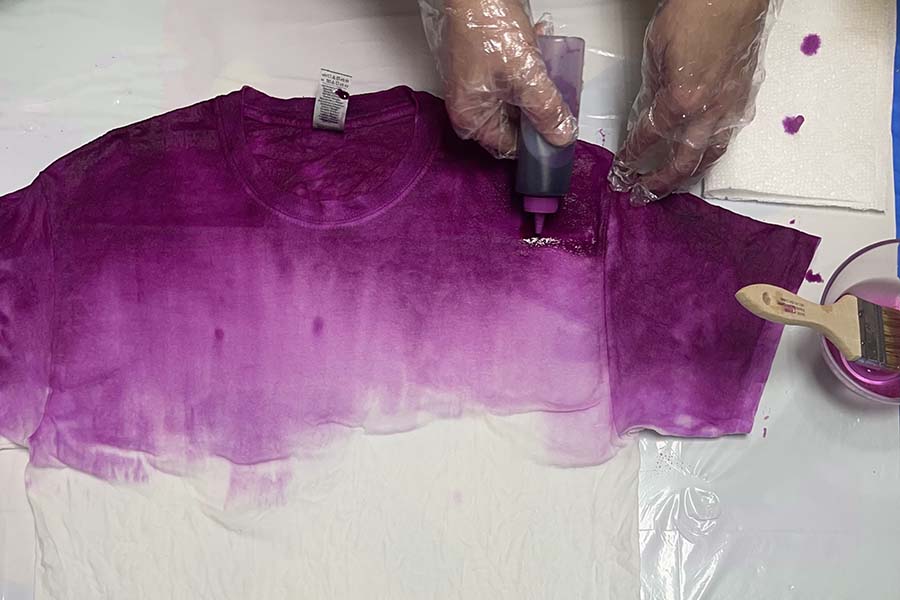 Applying more dye to light spots on shirt